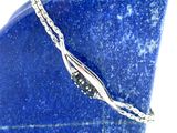 bracelet plaqué argent posé sur une plaque de marbre bleu, avec une chaîne en argent