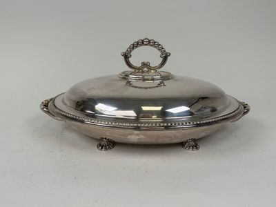 an antique silver plate with a domed lid on a stand