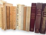 several books are lined up in a row on a white surface