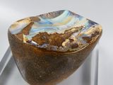 a brown and blue bowl sitting on top of a glass stand