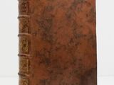 an old book sitting on top of a table next to a white wall