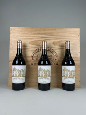 trois bouteilles de vin sont posées devant une caisse en bois