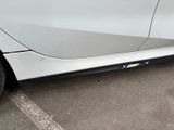 a close up of a white car parked in a parking lot