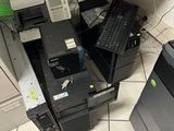 une pile d'ordinateurs et une imprimante posés par terre