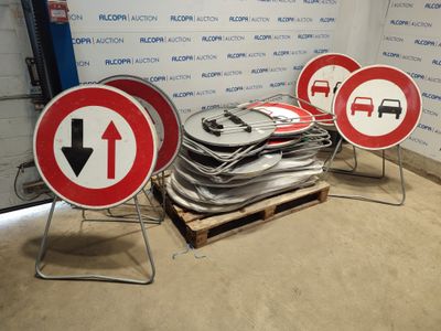 several red and white signs sitting on top of a pallet in front of a wall