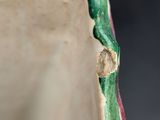 a close up of a green and white vase on a table