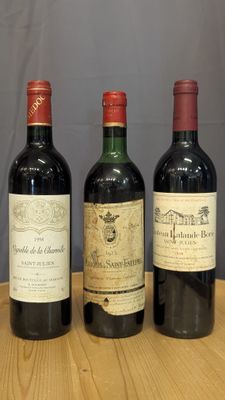 trois bouteilles de vin sont alignées sur une table en bois