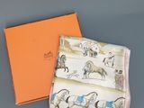 une boîte orange ornée d'un motif représentant un cheval et une calèche, à côté d'une boîte orange ornée d'un motif représentant un cheval et une calèche, à côté d'une boîte orange avec un cheval