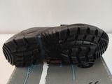 the sole of a pair of black hiking shoes on top of a box