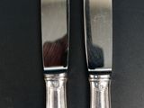 two knives that are sitting next to each other on a table