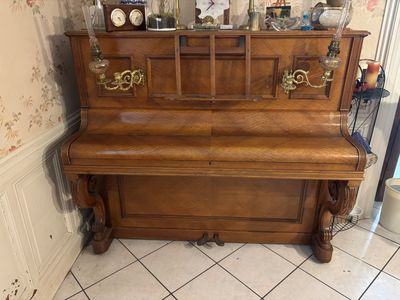 a piano in the corner of a room with a clock on top of it