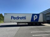 un gros semi-remorque garé devant un immeuble