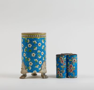 a blue and white vase with flowers on it next to a canister
