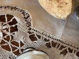 a cup of coffee sitting on a doily on a table