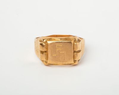 une image représentant une bague-sceau en or avec un sceau carré au centre