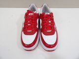 pair of red and white sneakers on a white surface
