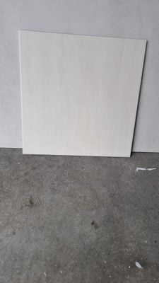 un morceau de papier blanc posé par terre près d'un mur