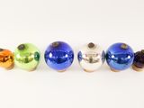 four different colored glass ornaments on a white surface