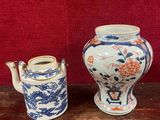 trois vases posés sur une table, sur fond rouge