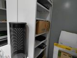an image of a room with a desk, shelves, and a speaker