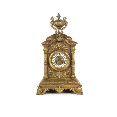 une horloge en or posée sur une surface blanche