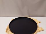 une assiette noire posée sur une table blanche