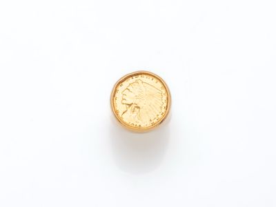 gros plan d'une pièce d'or sur une surface blanche