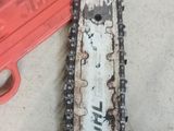 a close up of a chainsaw on a table next to a tool