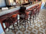 a row of bar stools in a restaurant with a checkered floor
