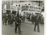 photo en noir et blanc d'un groupe d'hommes marchant dans une rue