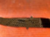 a close up of a knife on a wooden table