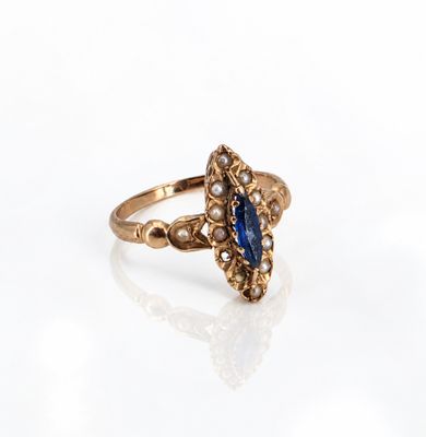 a close up of a gold ring with a blue stone and pearls