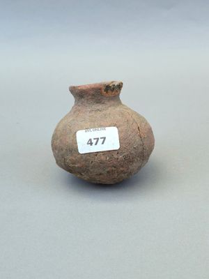 un petit vase muni d'une étiquette, posé sur une table