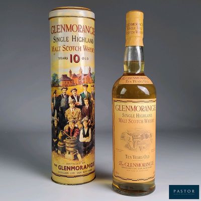 an old bottle of glenmore ' s 10 year old scotch whisky next to a canister