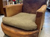 a brown chair with a cushion on it in a room