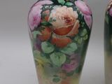 two vases with flowers painted on them on a white surface