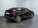 the rear end of a black car parked in a room