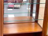 a display case with glass shelves in the middle of a room