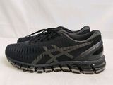 un gros plan sur une paire de chaussures de course noires posées sur une surface blanche