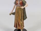 figurine représentant une femme tenant un parapluie, posée sur un socle en bois