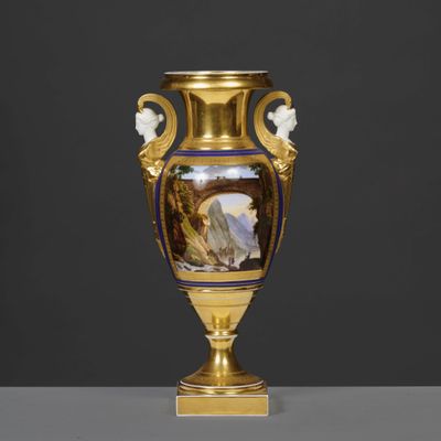 un vase en or orné d'une peinture, posé sur une table