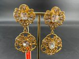 a close up of a pair of earrings on a stand