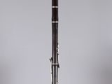 a close up of a clarinet in a clear box on a gray background