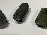 three different models of military vehicles displayed on a table
