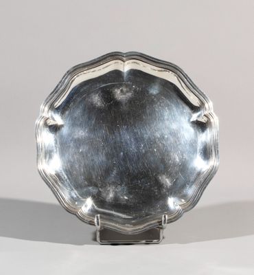 a silver plate that is on a stand on a table