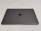 a black apple laptop sitting on a white surface