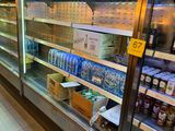 bottles of beer are on display in a cooler at a grocery store
