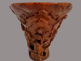 a wooden vase with carvings on it on a gray background