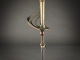 a close up of a sword on a stand on a dark surface