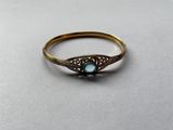 gros plan d'une bague en or avec une pierre bleue